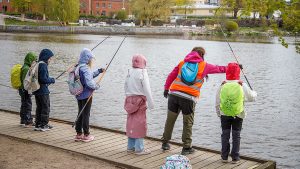 Koululaiset onkimassa Valtakunnallisen kalastuspäivän tapahtumassa Vanhankaupunginkosken suvannolla Helsingissä toukokuussa.